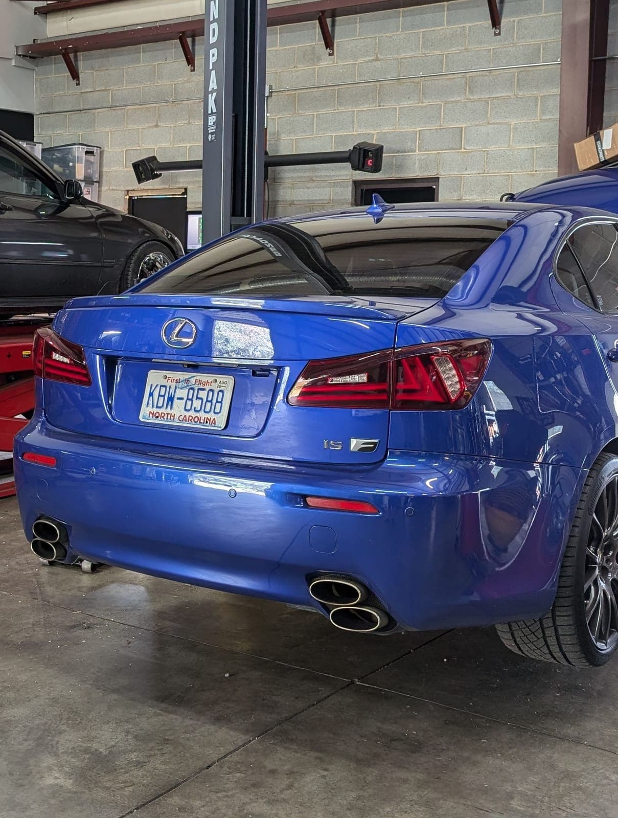 Rear view of a blue Lexus IS F with quad exhaust tips inside the Streamline Performance Garage shop