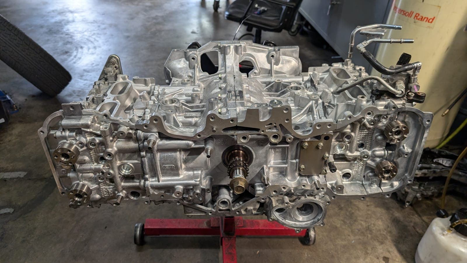 Bare Subaru boxer engine block and heads on an engine stand on the shop floor at Streamline Performance Garage in Concord, NC